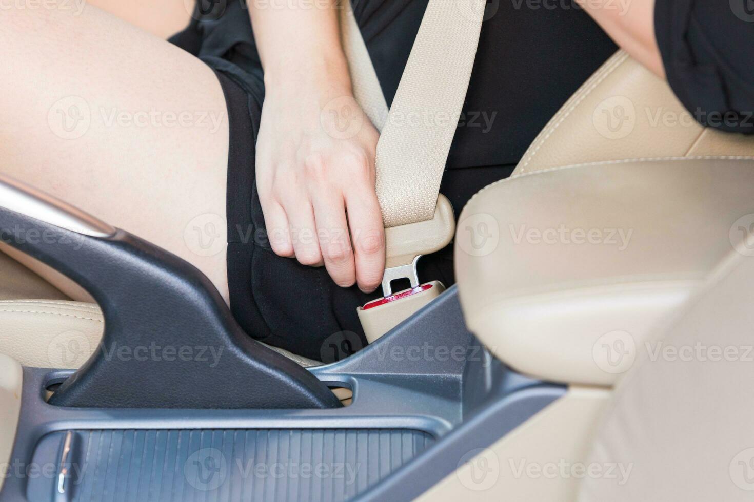 Women hand fastening seat belt inside car. photo