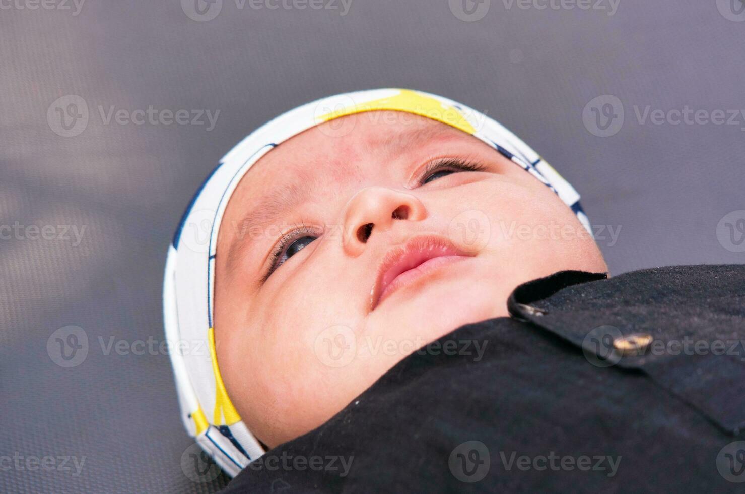 Close Up Shot of Cute Asian Pakistani 4 Months Old Baby Boy, Who is Enjoying at Home Garden at Luton City of England UK. Image Was Captured on July 23rd, 2023 photo