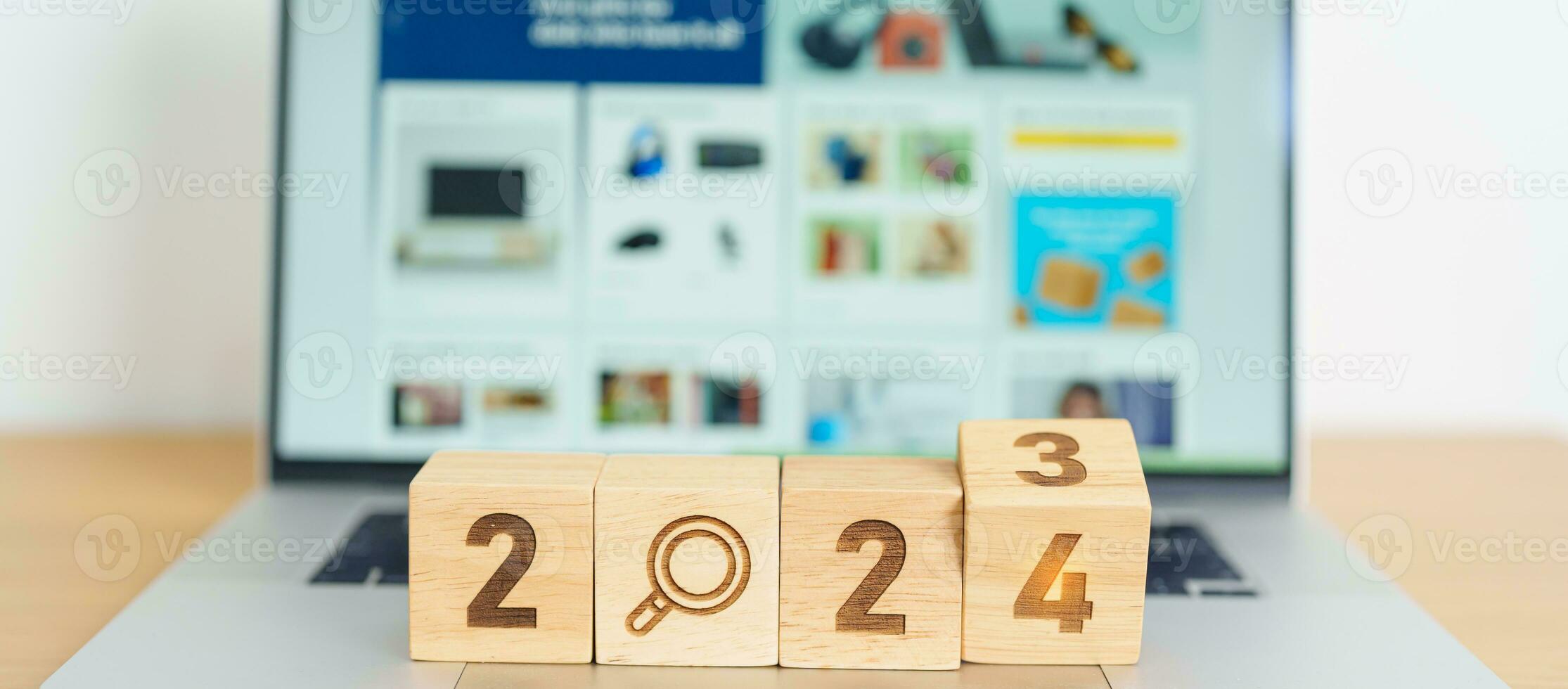 2024 block with magnifying glass icon against laptop background. Hiring, recruitment, job, jobless SEO, Search Engine Optimization and New Year concepts photo
