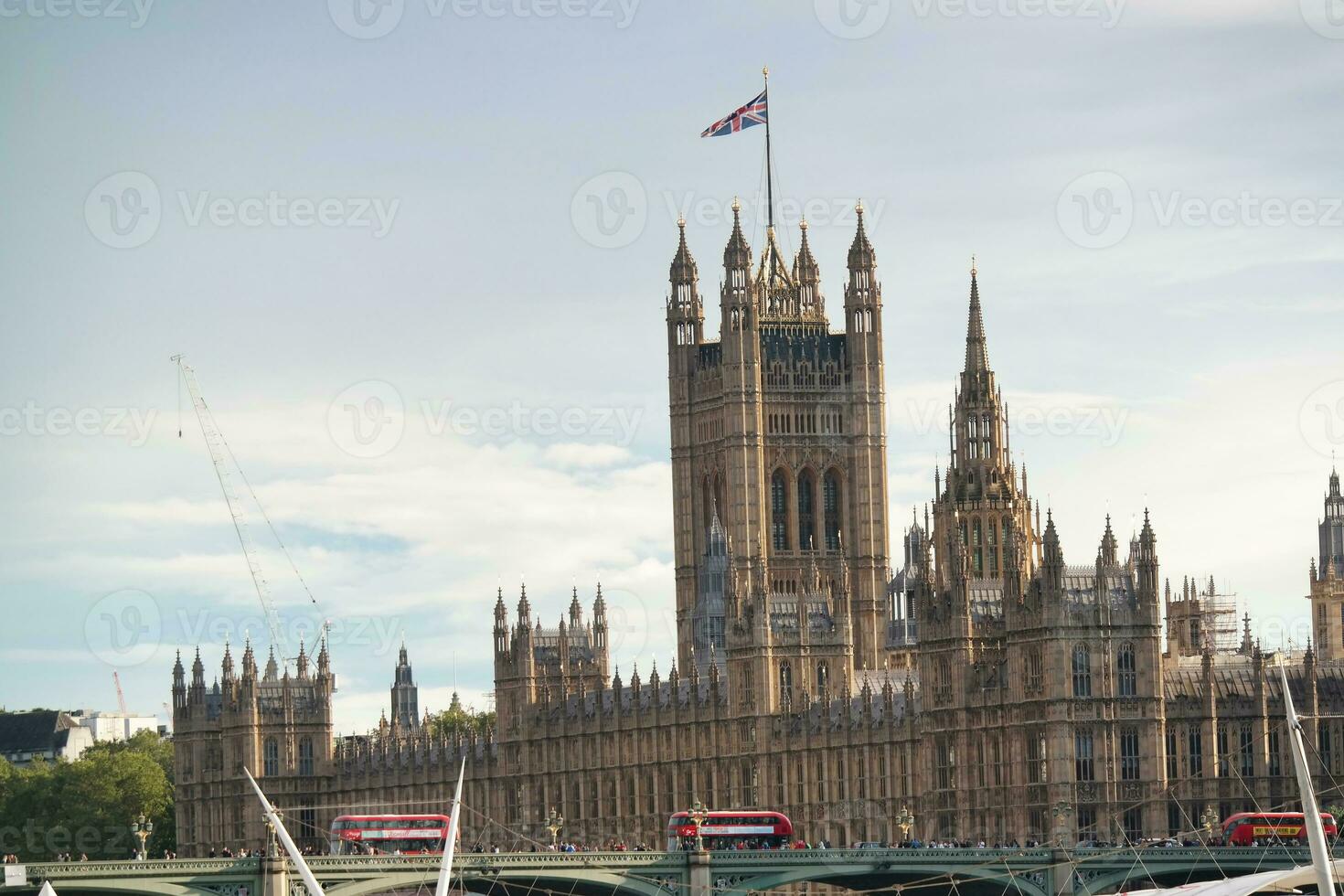 Beautiful Low Angle View of Historical Big Ben Clock Tower from river Thames and London Eye, Westminster Central London, England Great Britain, UK. Image Captured During Cloudy Day of August 2nd, 2023 photo