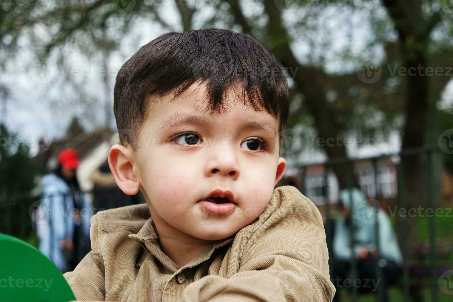 Cute Asian Pakistani Baby is Enjoying The Beautiful Sunny Day at Wardown Children and Public Park of Luton Town of England UK. Low Angle  Image Was Captured on April 03rd, 2023 photo