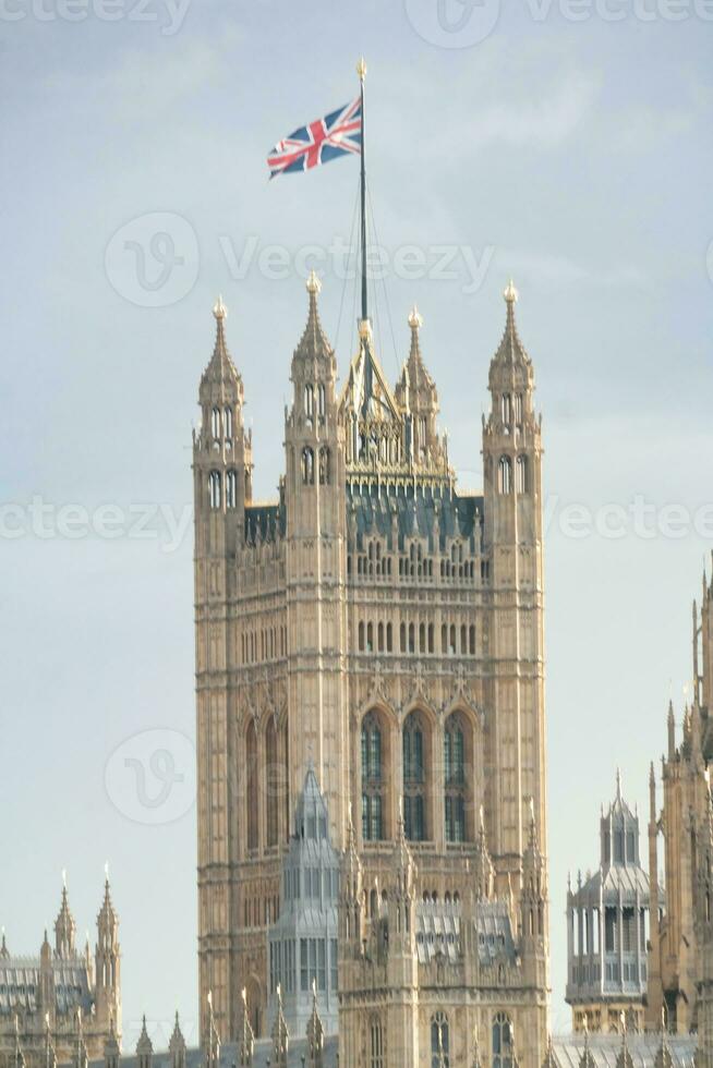 Beautiful Low Angle View of Historical Big Ben Clock Tower from river Thames and London Eye, Westminster Central London, England Great Britain, UK. Image Captured During Cloudy Day of August 2nd, 2023 photo