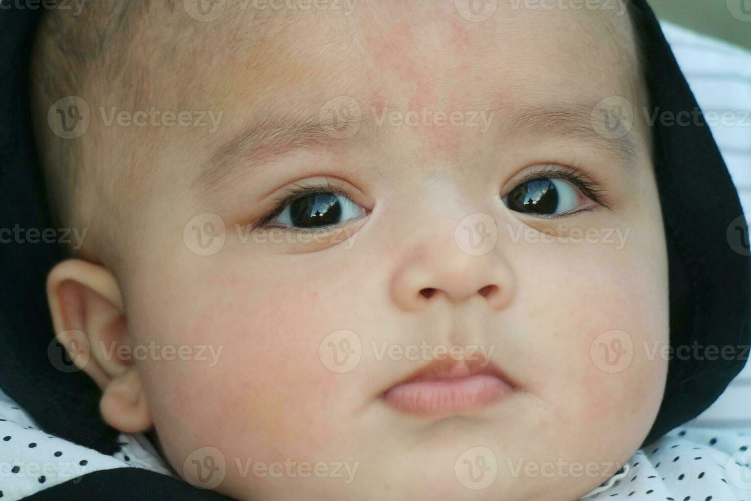 Close Up Shot of Cute Asian Pakistani 4 Months Old Baby Boy, Who is Enjoying at Home Garden at Luton City of England UK. Image Was Captured on July 23rd, 2023 photo