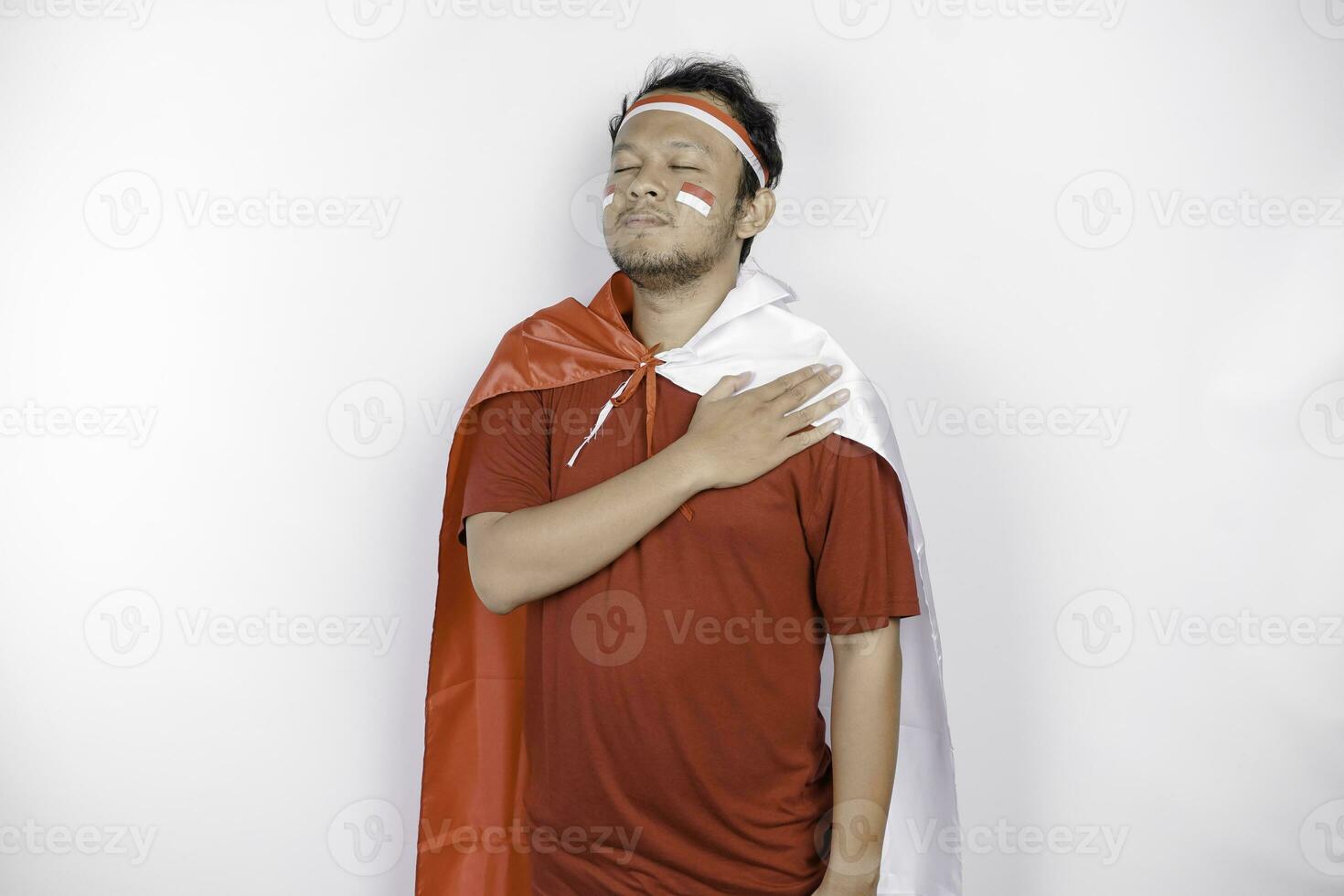 Indonesian man give salute with proud gesture while holding Indonesia's flag. Indonesia's independence day concept. photo