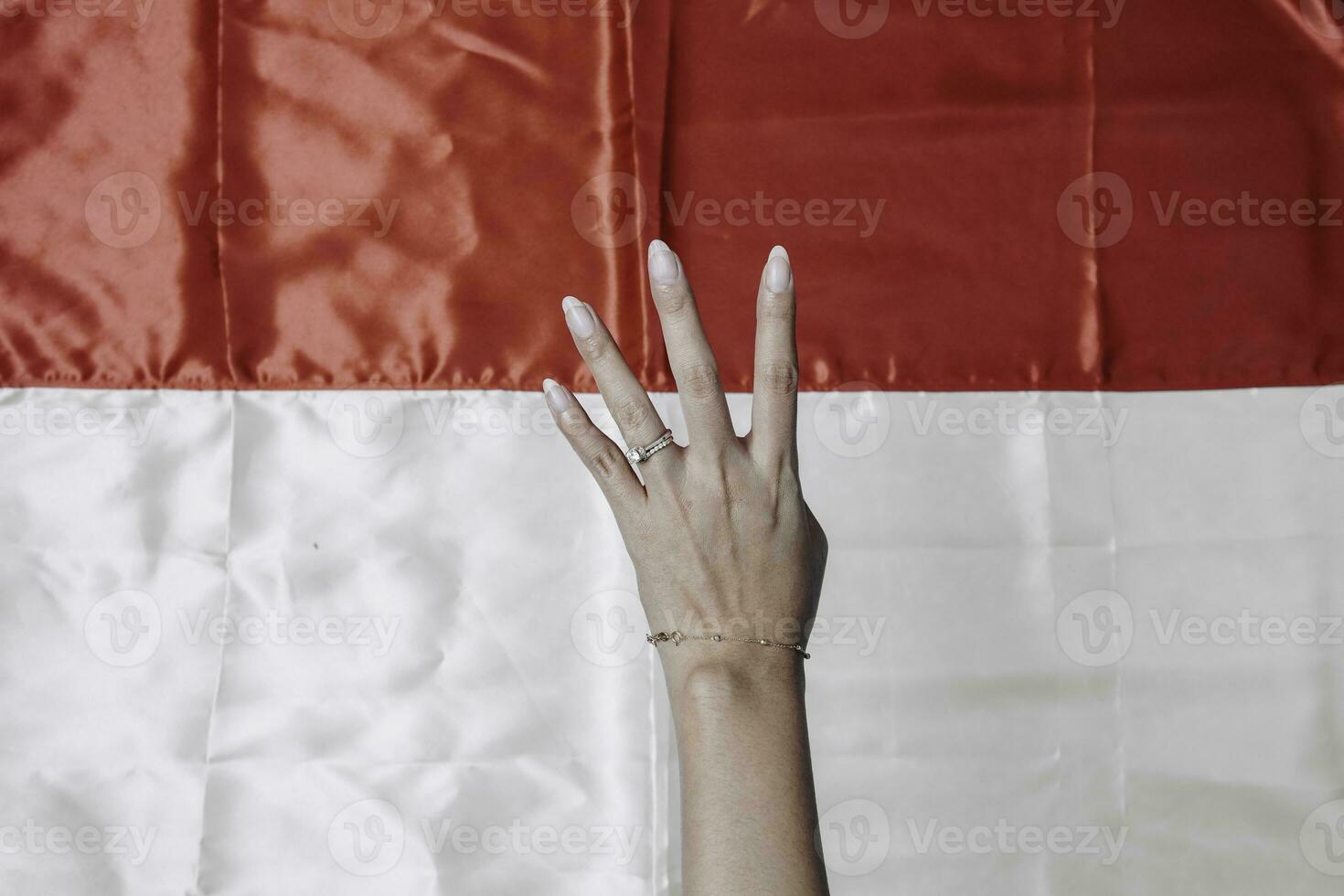 Hands gesturing signs of number isolated by Indonesian red and white flag. Indonesia's independence day concept photo