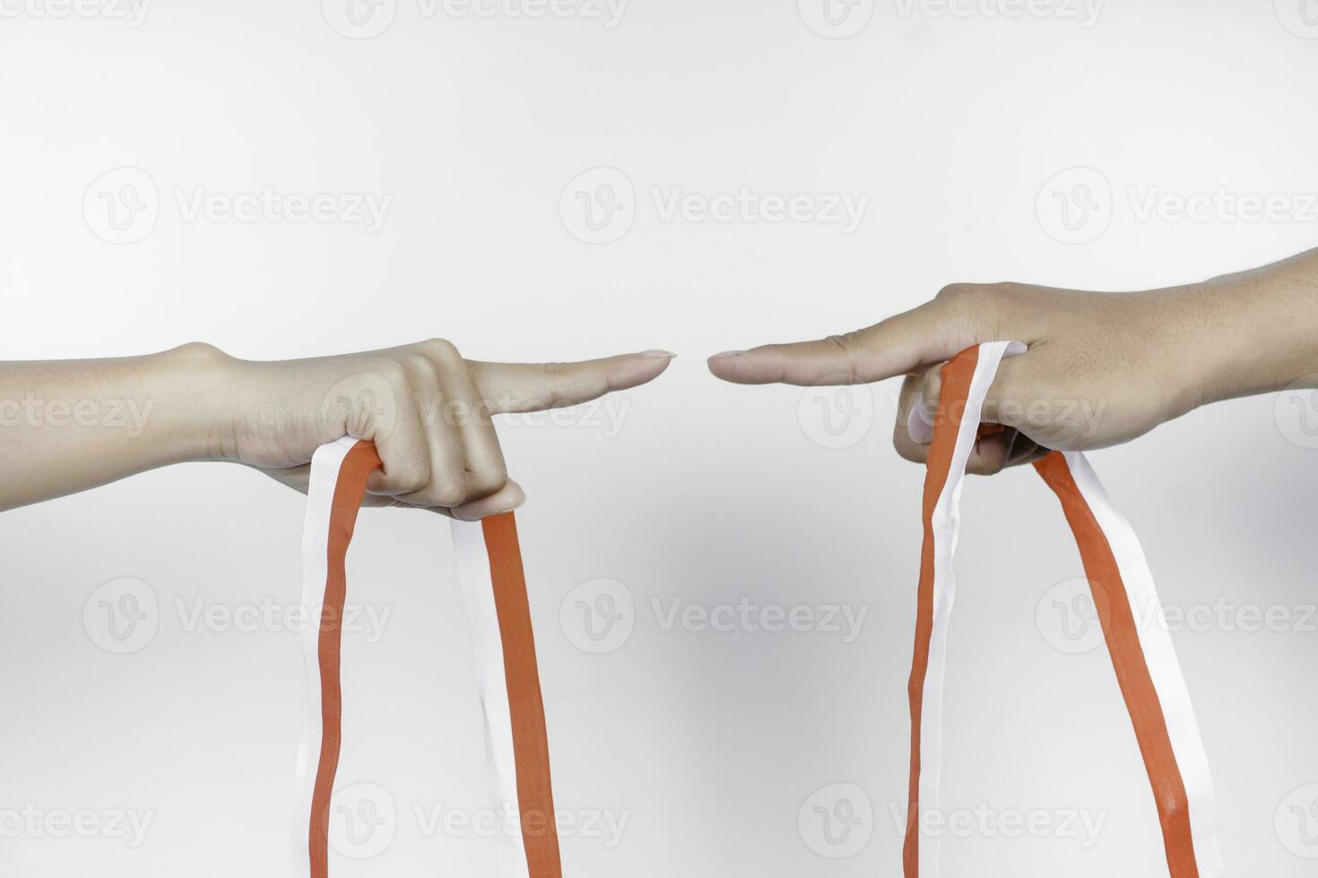 hands put together holding Indonesian red and white ribbon. Indonesia's independence day concept photo