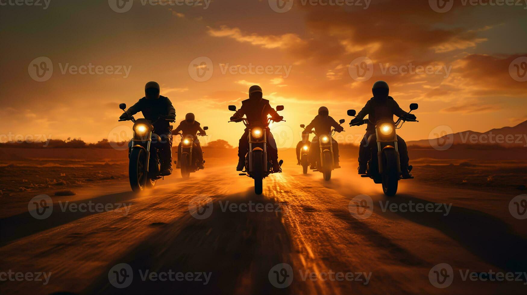 Motorcyclists riding on the road in the desert during sunset. photo