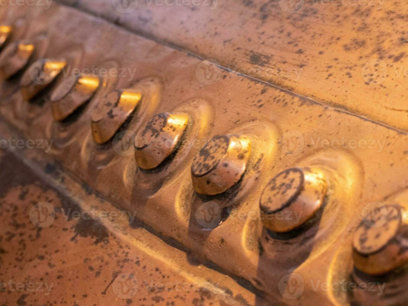 Metal background, old copper wall with rivets photo