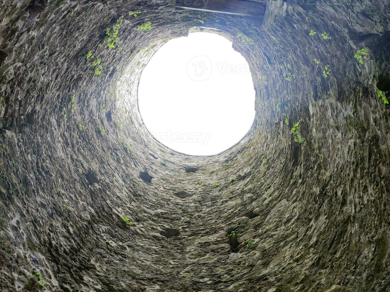 Stone well hole, old construction from inside, fall down in the well photo