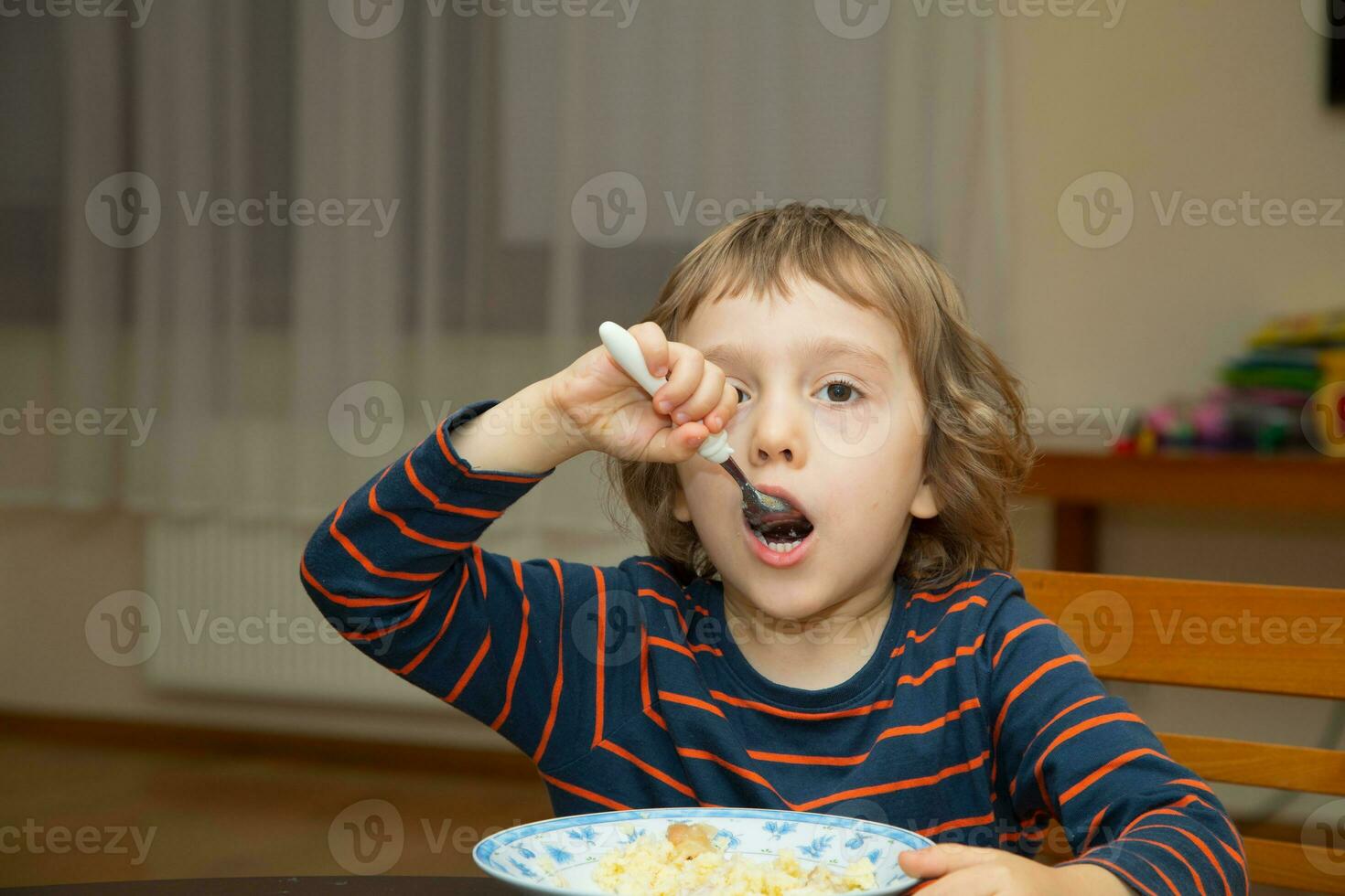 a young boy eating cereal photo