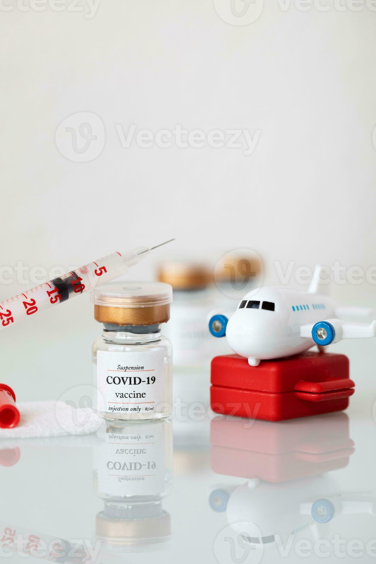 a syringe and a small toy airplane on a table 27444958 Stock Photo at