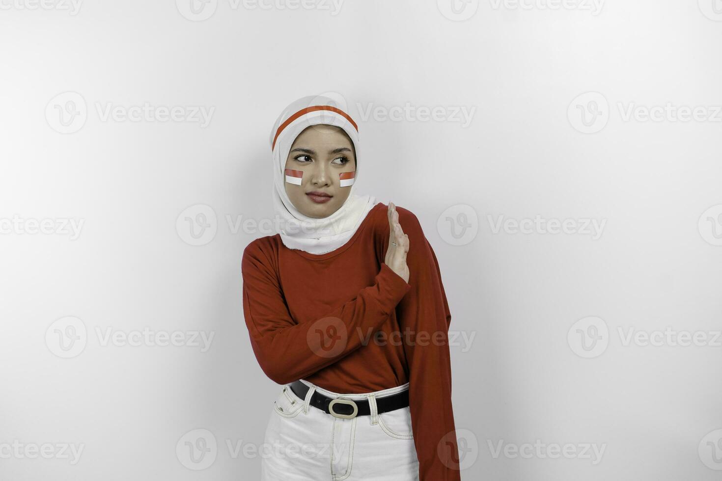 Beautiful Asian Muslim woman wearing a hijab with hand gesture pose rejection or prohibition with copy space. Indonesia's independence day concept. photo