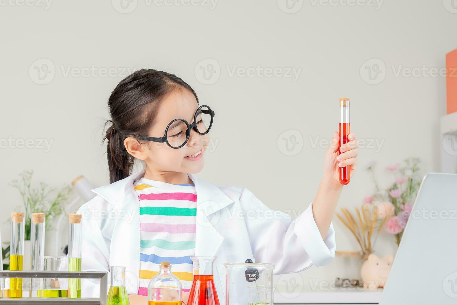 asiático pequeño niña trabajando con prueba tubo Ciencias experimentar en blanco salón de clases foto