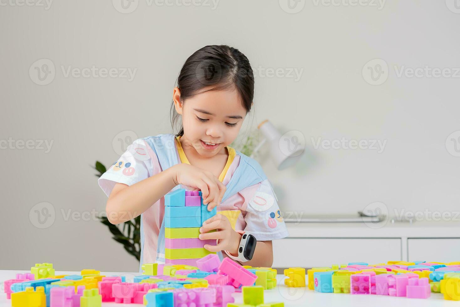 little girl is happy Playing colorful block puzzles. in the white room photo