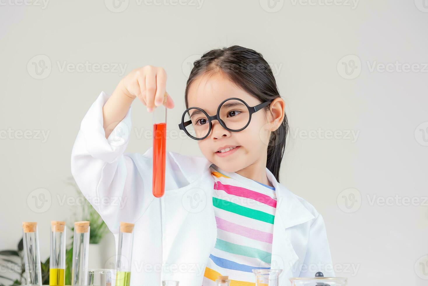 Asian little girl working with test tube science experiment in white classroom photo