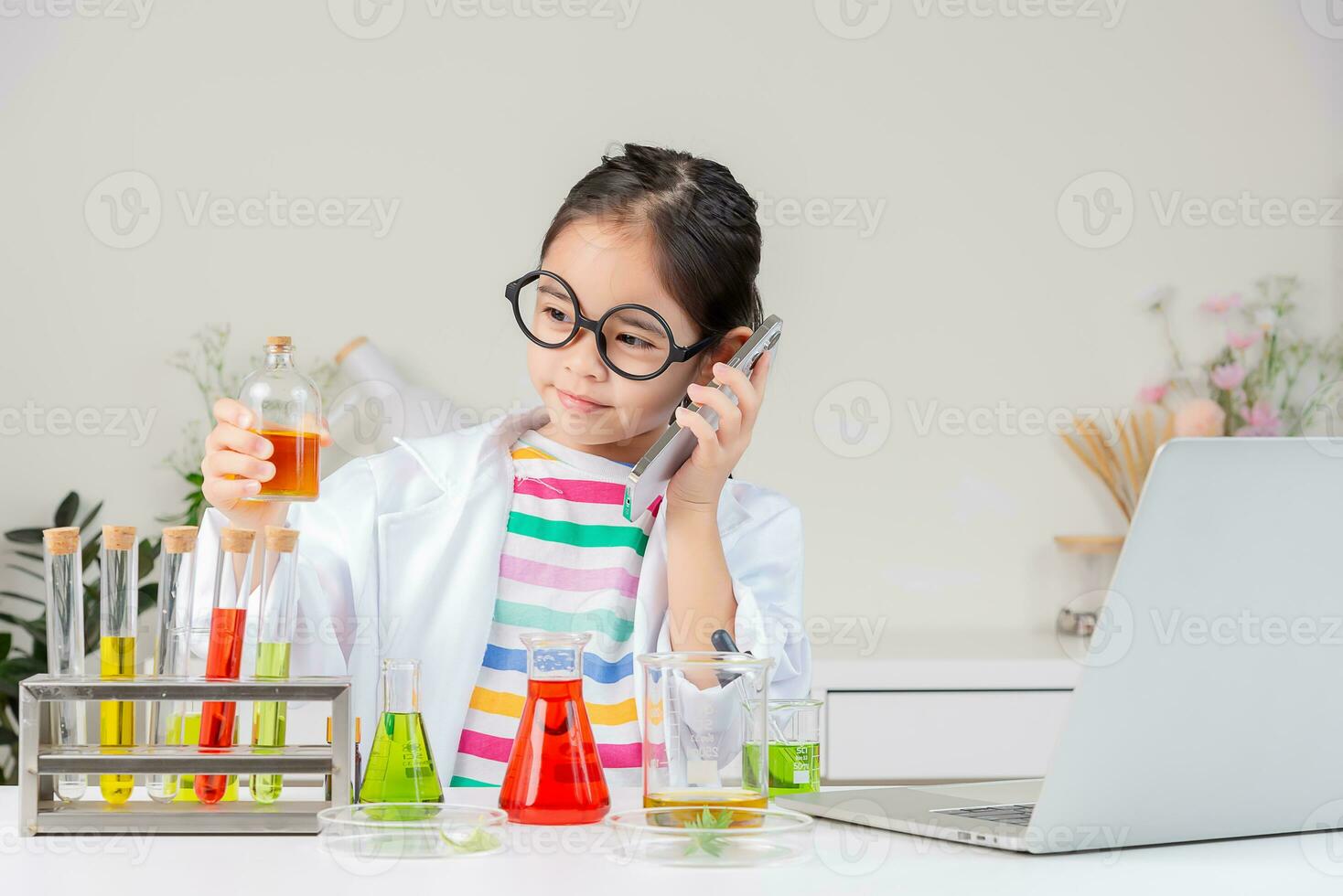 Asian little girl working with test tube science experiment in white classroom photo