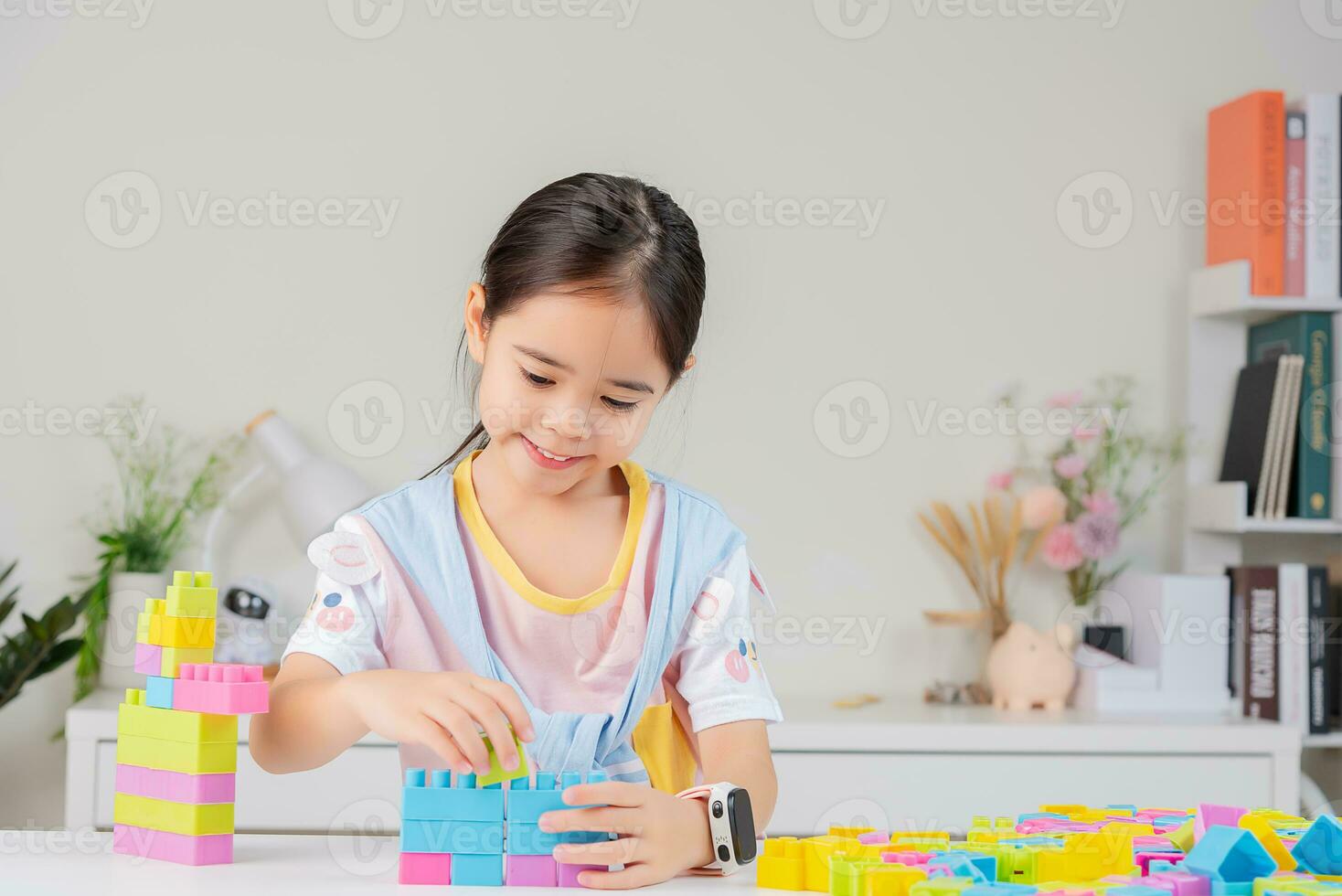little girl is happy Playing colorful block puzzles. in the white room photo