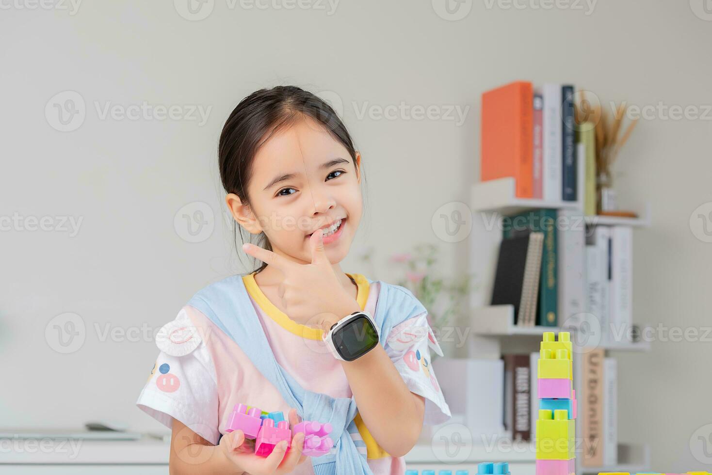 little girl is happy Playing colorful block puzzles. in the white room photo
