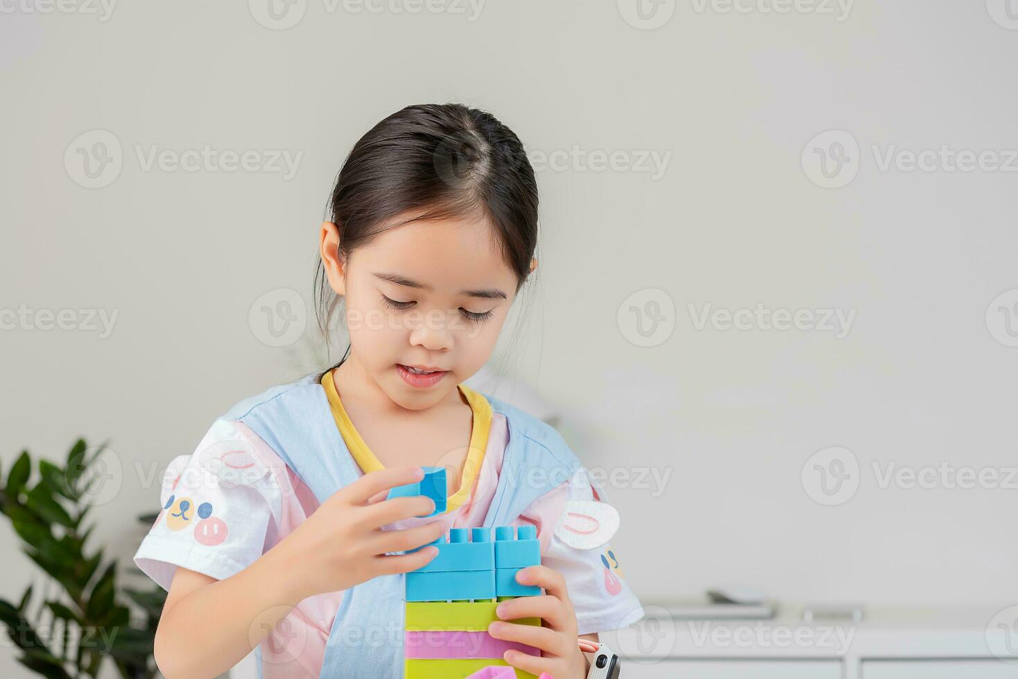 little girl is happy Playing colorful block puzzles. in the white room photo