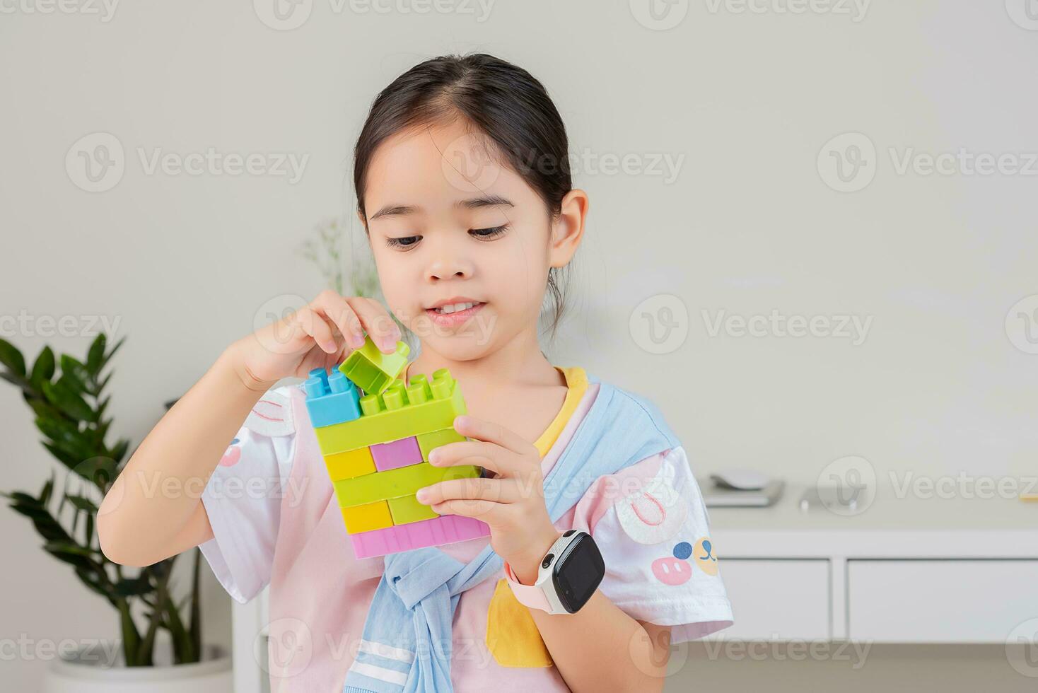 little girl is happy Playing colorful block puzzles. in the white room photo