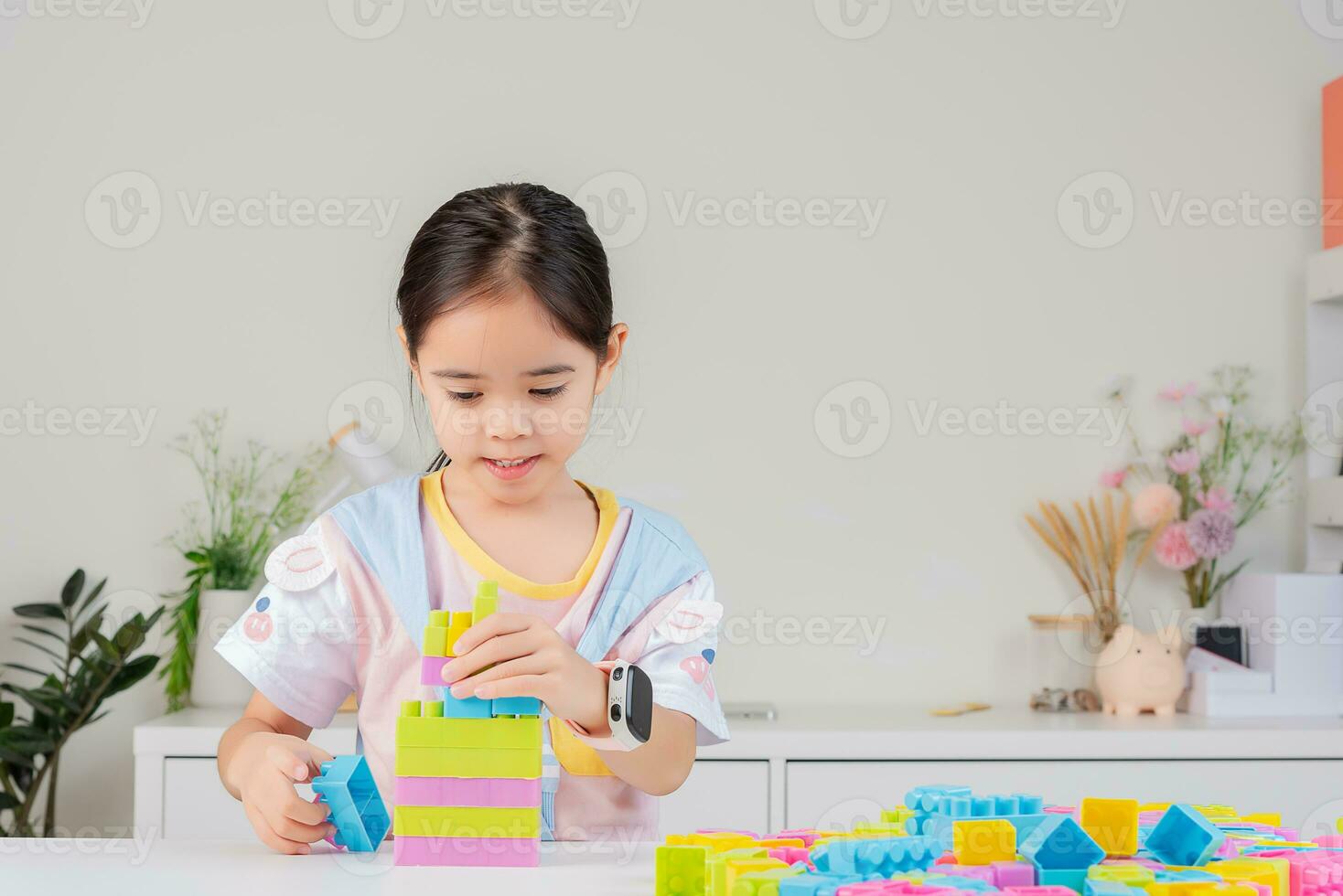 little girl is happy Playing colorful block puzzles. in the white room photo
