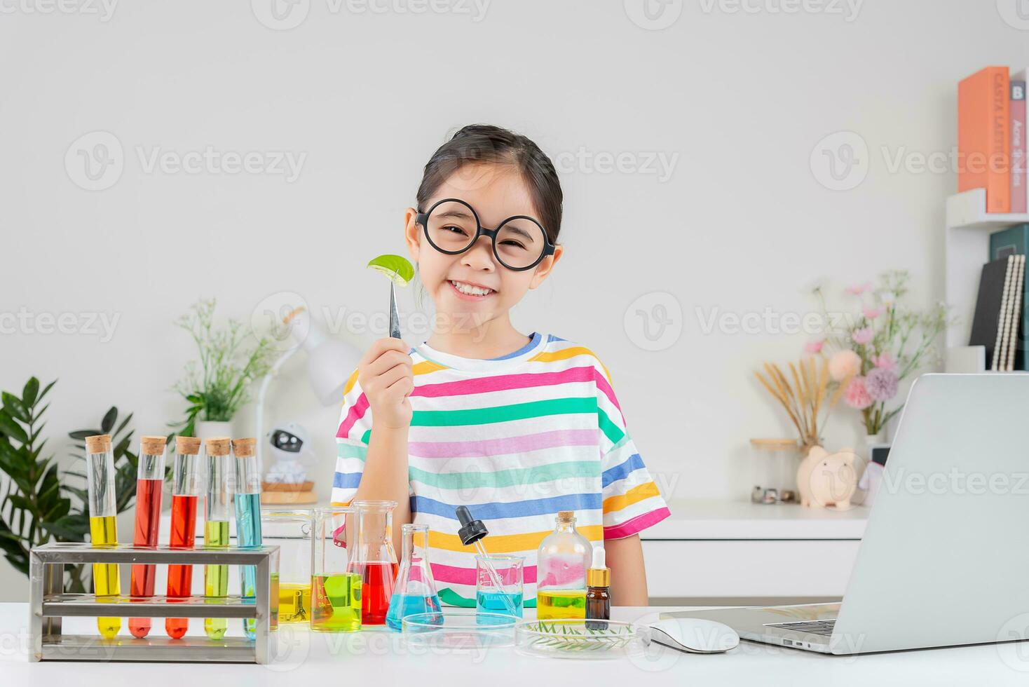 Asian little girl working with test tube science experiment in white classroom photo