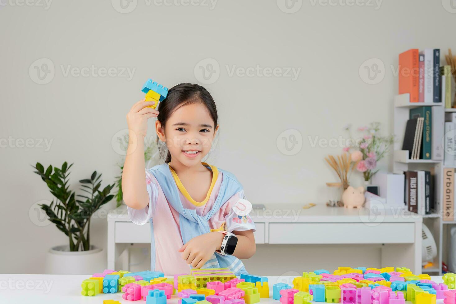 little girl is happy Playing colorful block puzzles. in the white room photo