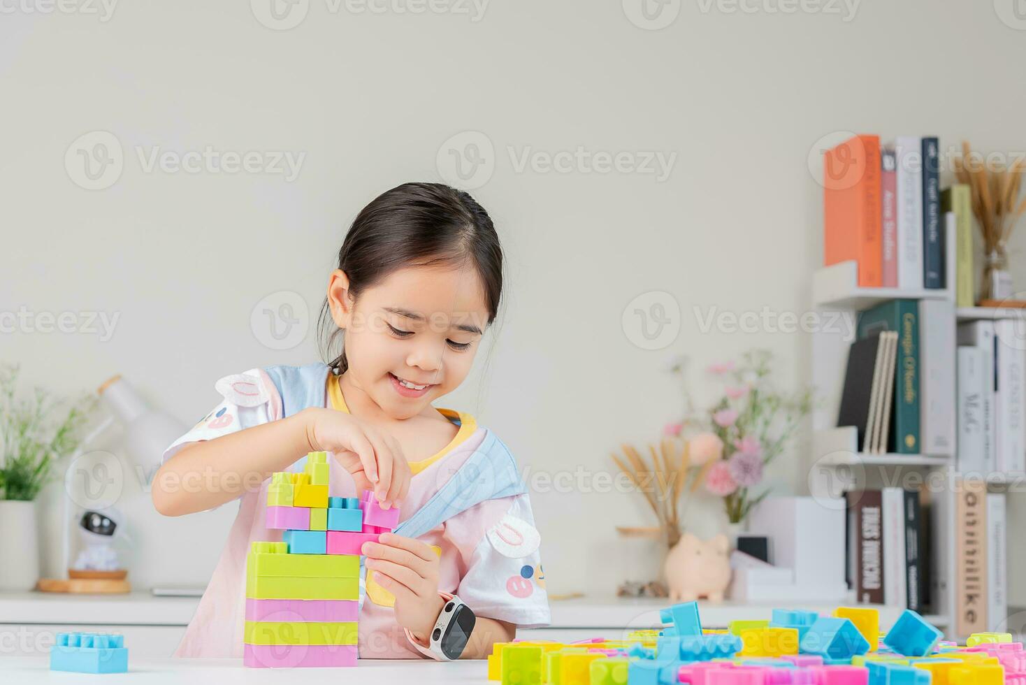 little girl is happy Playing colorful block puzzles. in the white room photo