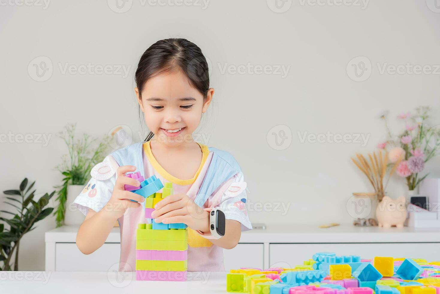 little girl is happy Playing colorful block puzzles. in the white room photo