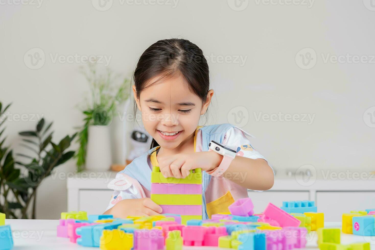 little girl is happy Playing colorful block puzzles. in the white room photo