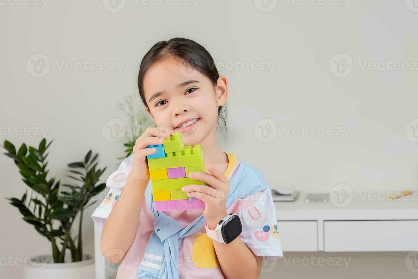 little girl is happy Playing colorful block puzzles. in the white room photo