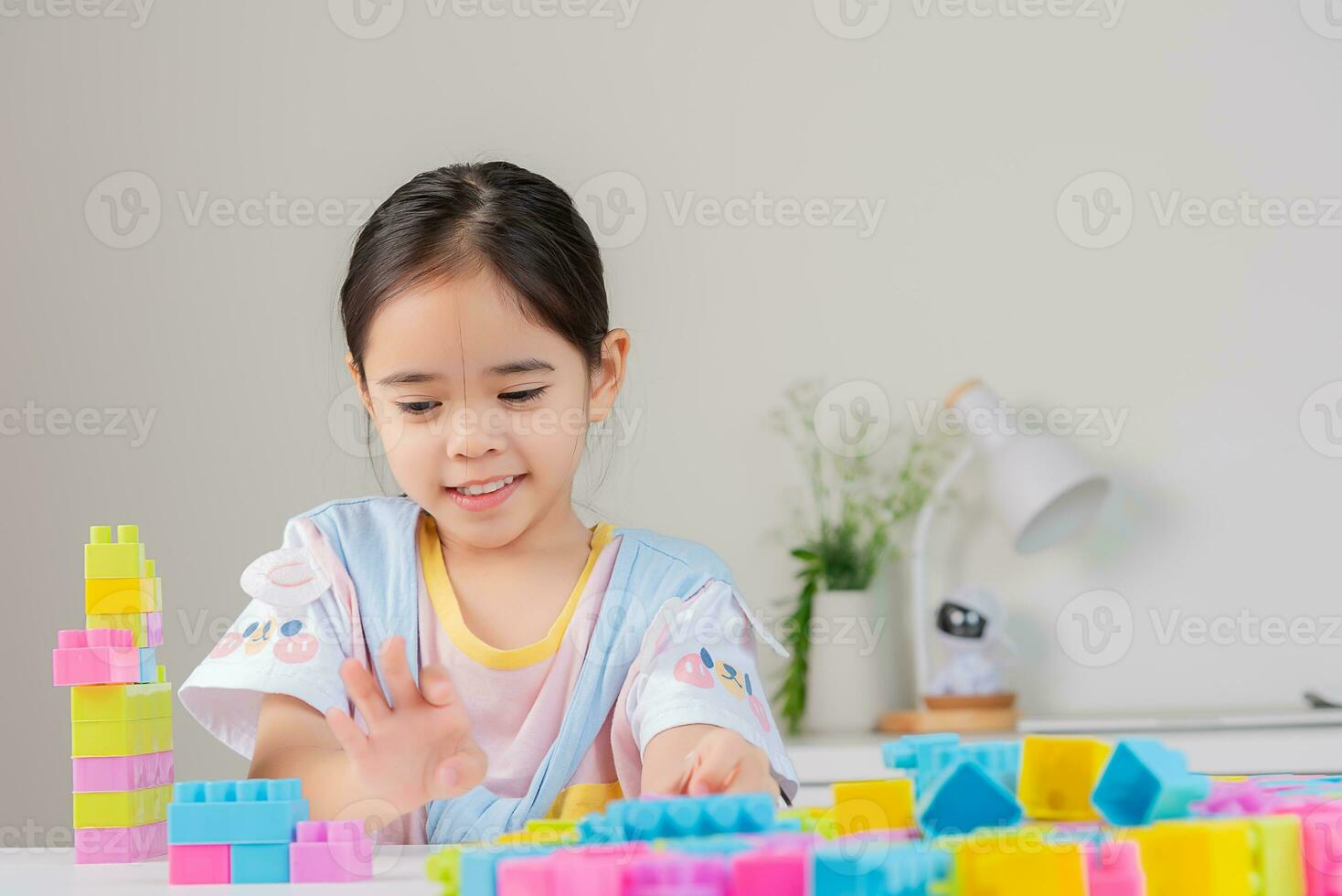 little girl is happy Playing colorful block puzzles. in the white room photo