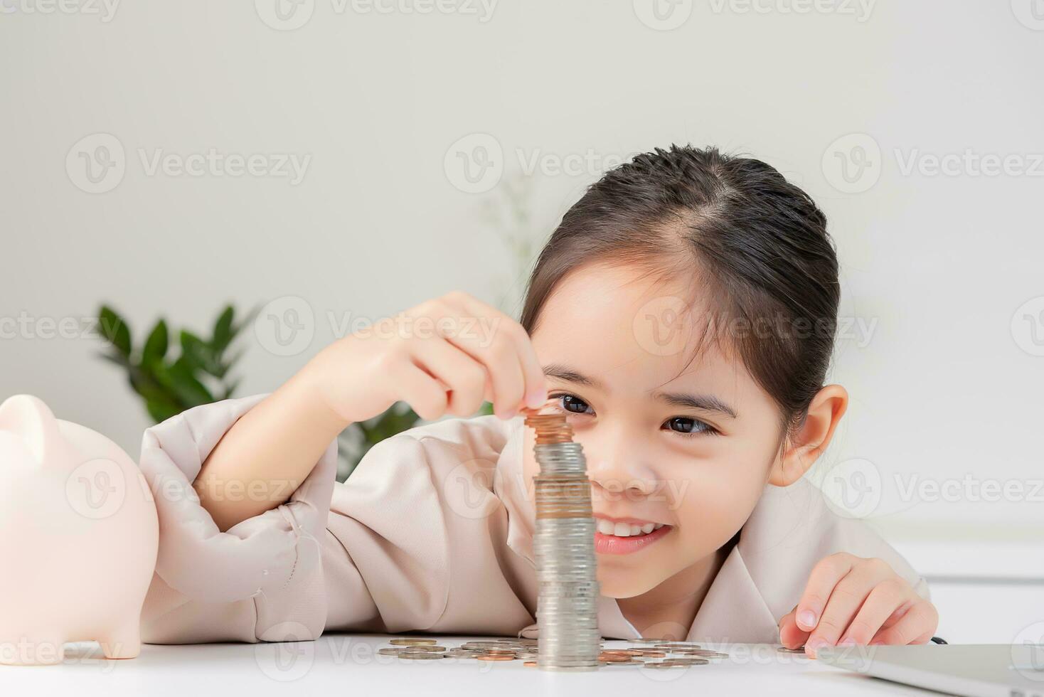 asiático pequeño linda niña vistiendo un crema traje analizando monedas Finanzas y inversión foto