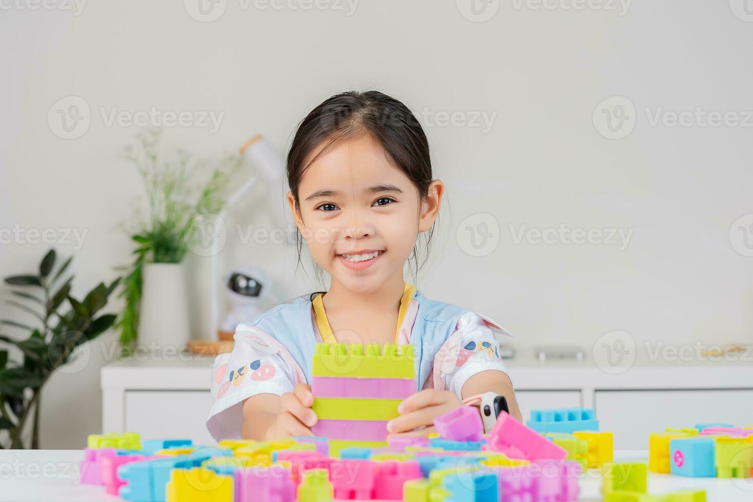 little girl is happy Playing colorful block puzzles. in the white room photo