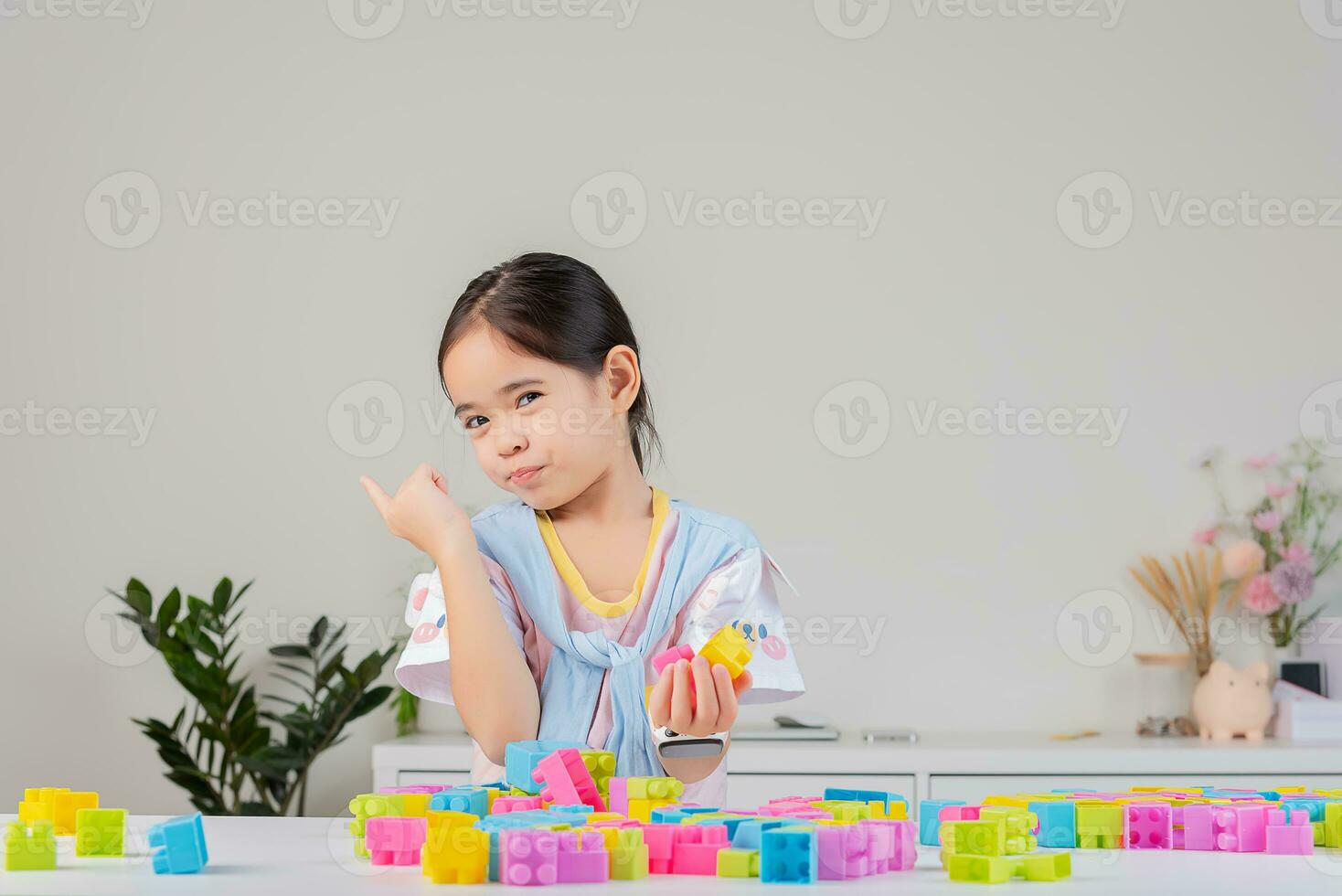 little girl is happy Playing colorful block puzzles. in the white room photo