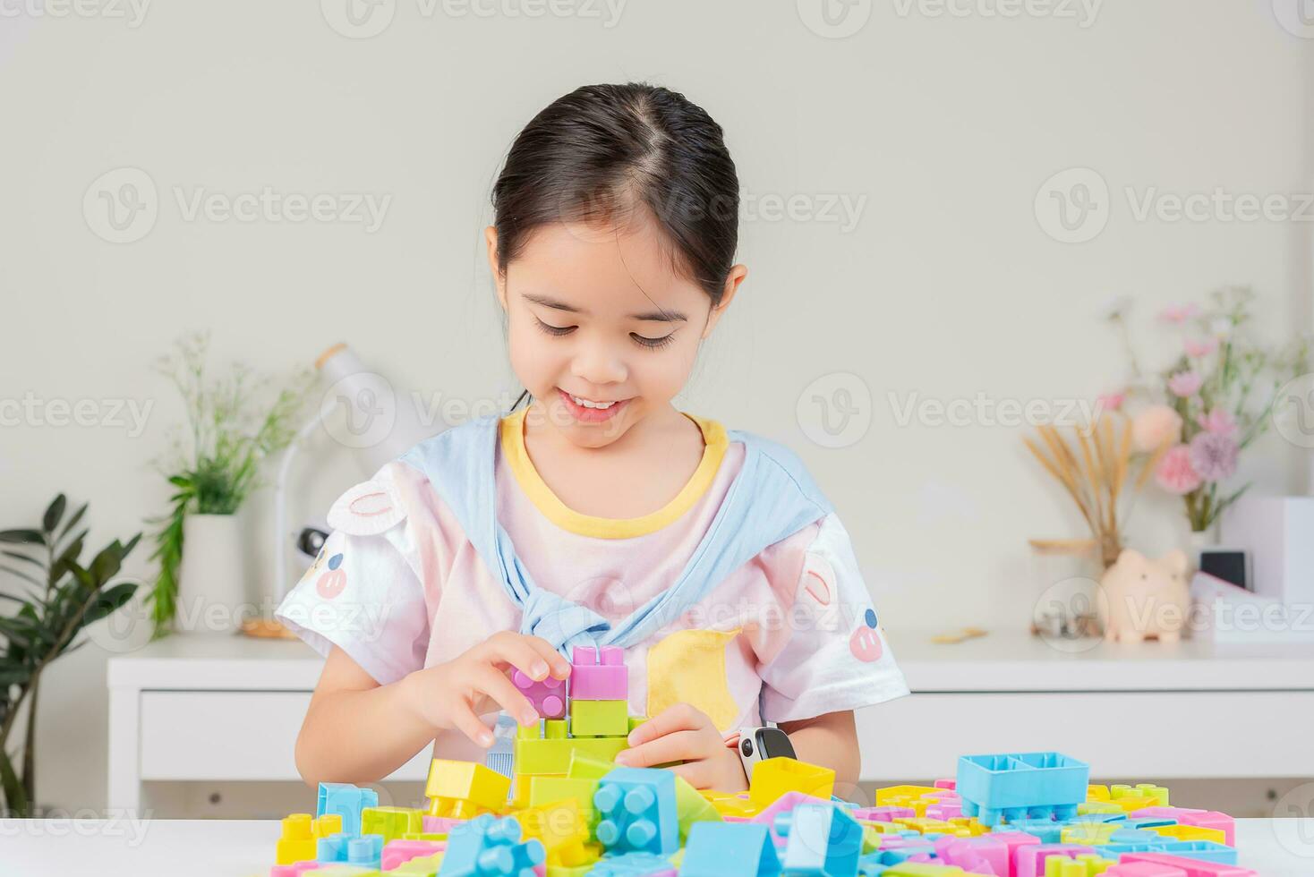 little girl is happy Playing colorful block puzzles. in the white room photo