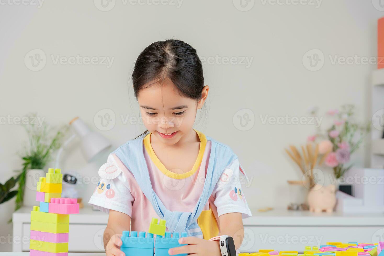 little girl is happy Playing colorful block puzzles. in the white room photo