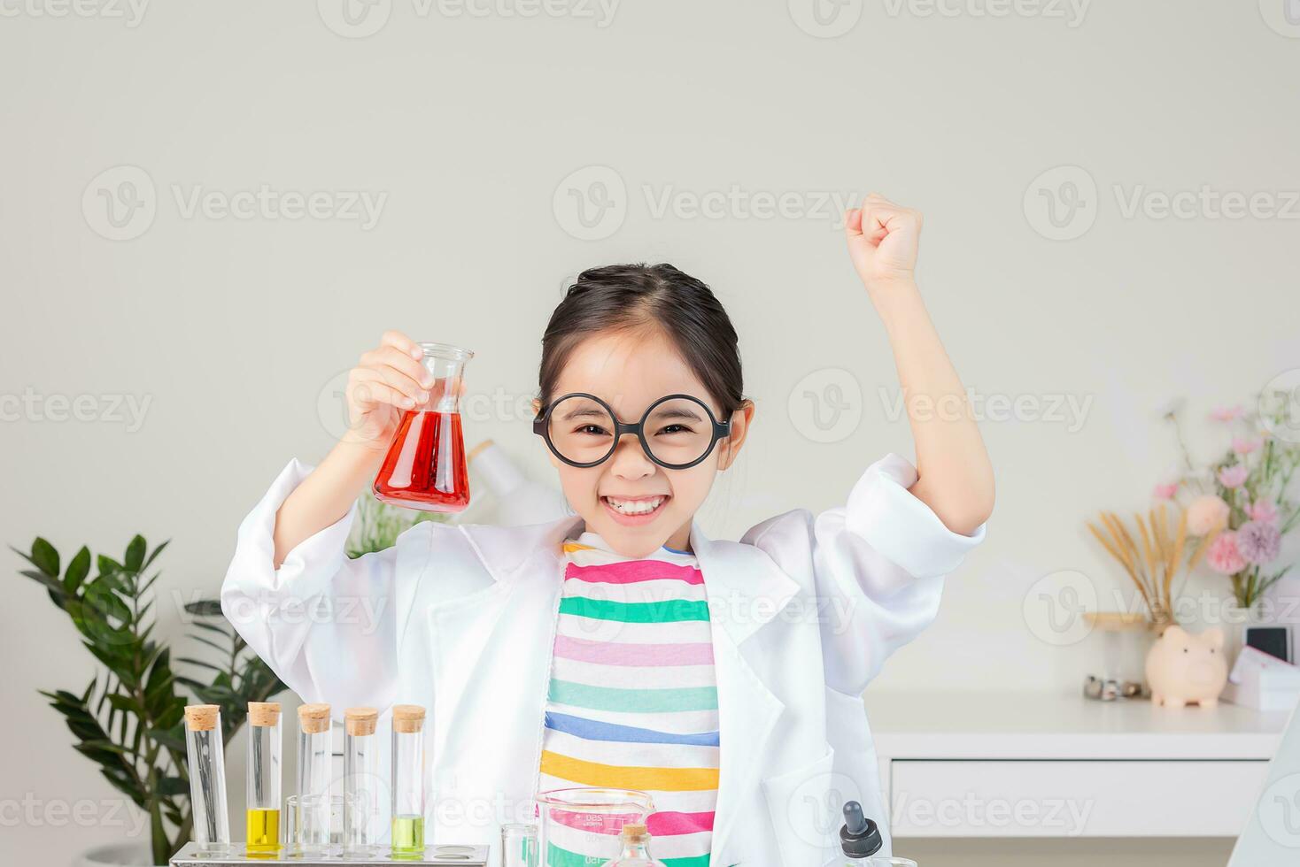 Asian little girl working with test tube science experiment in white classroom photo