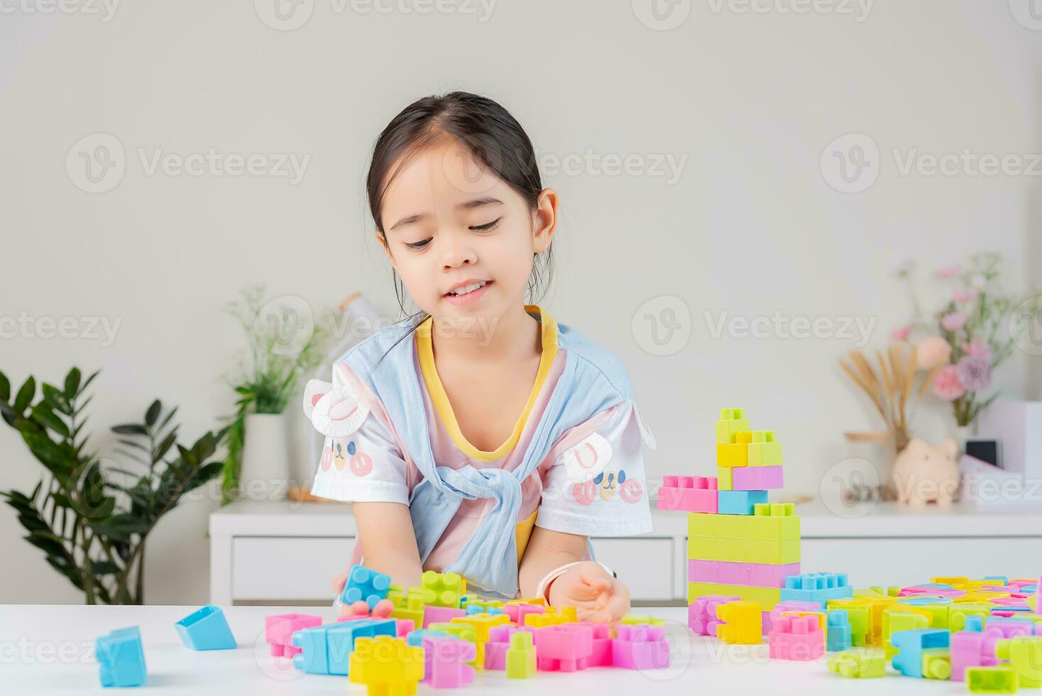 little girl is happy Playing colorful block puzzles. in the white room photo