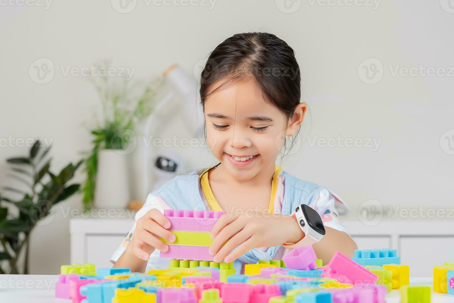 little girl is happy Playing colorful block puzzles. in the white room photo