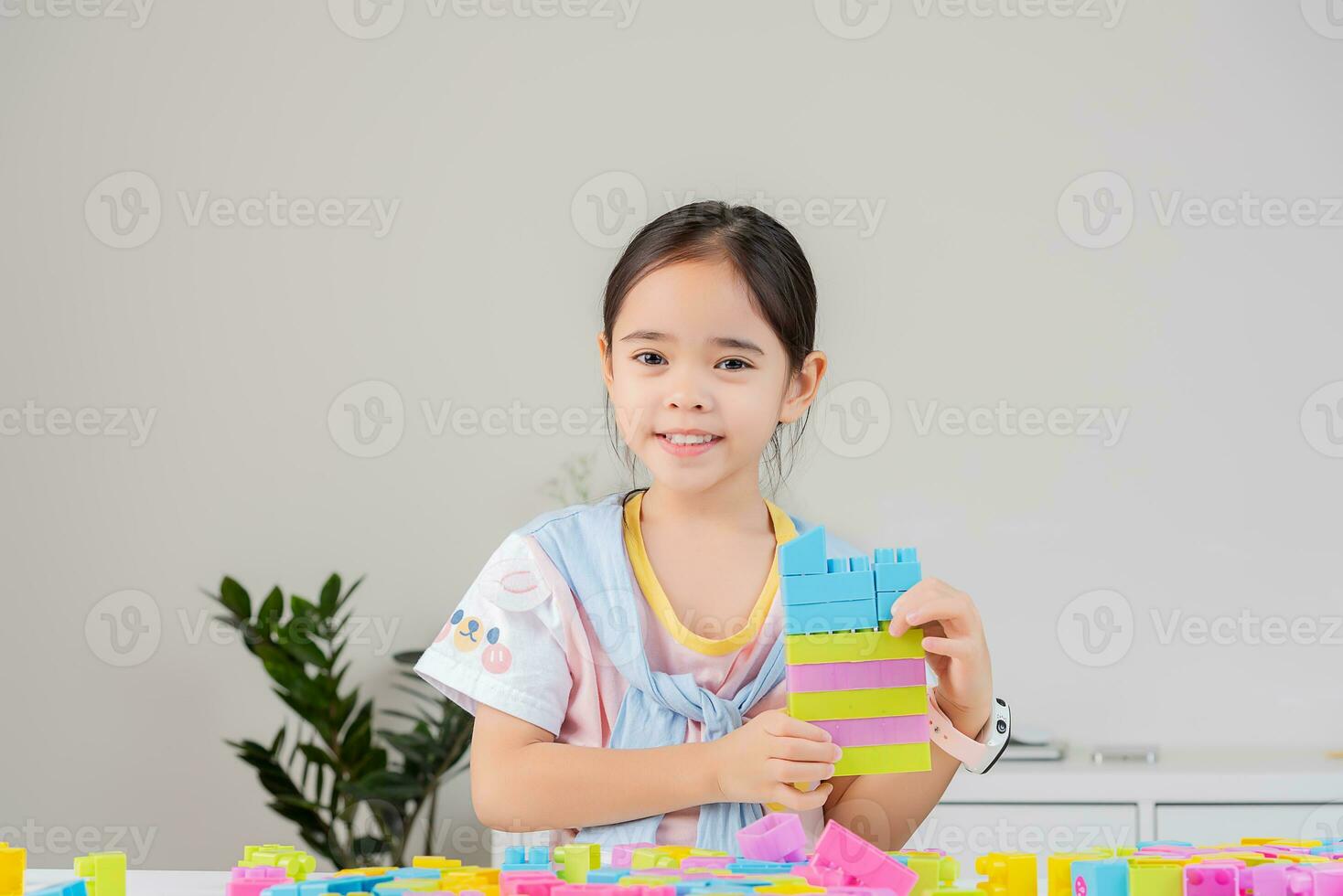 little girl is happy Playing colorful block puzzles. in the white room photo