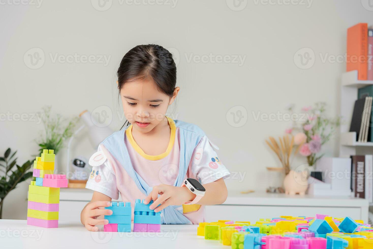 little girl is happy Playing colorful block puzzles. in the white room photo