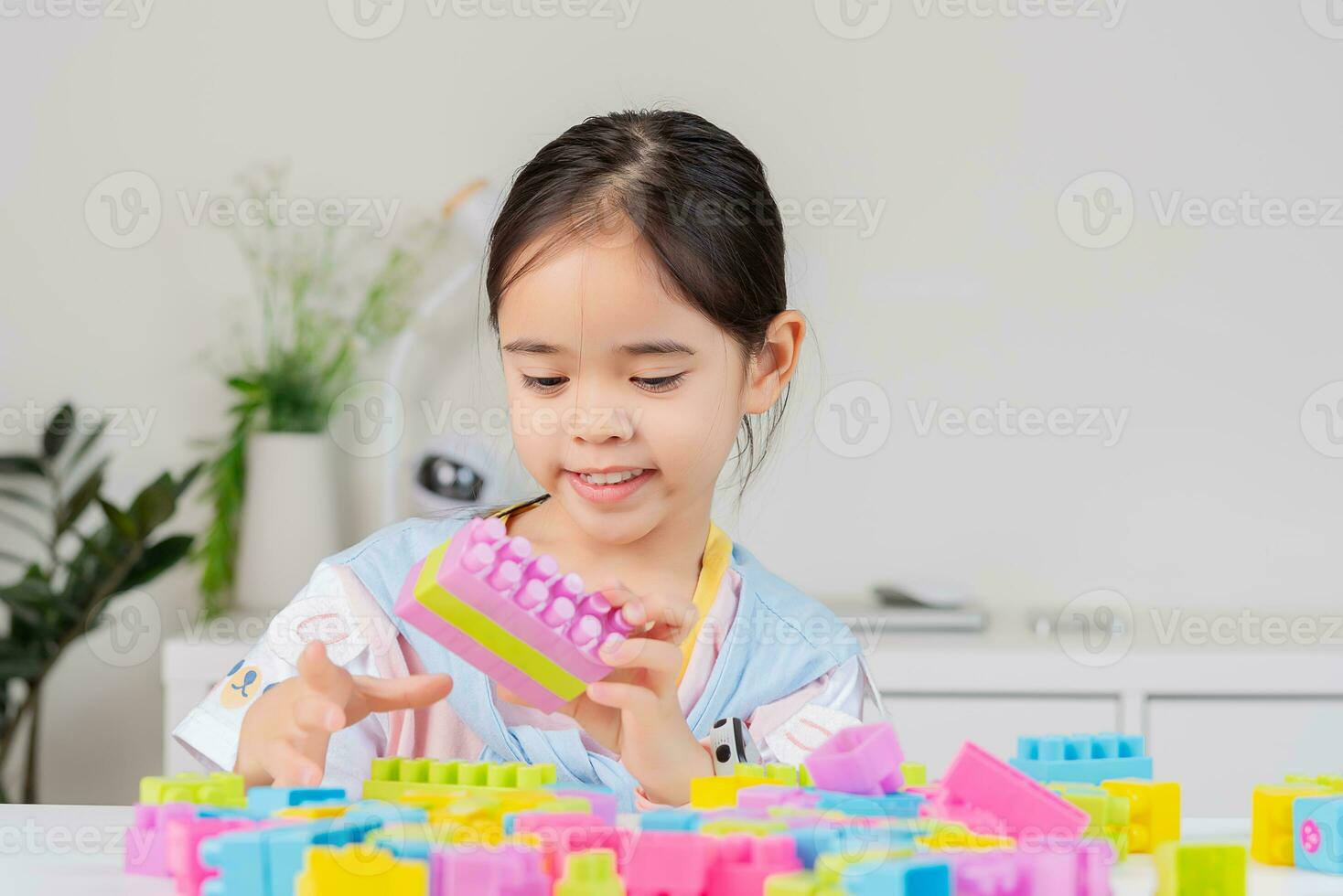 little girl is happy Playing colorful block puzzles. in the white room photo