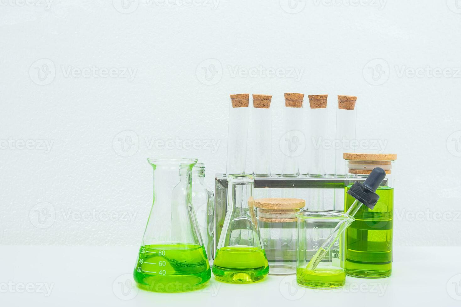 A glass beaker containing water and Centella asiatica decorated with erlenmeyer flask and round podium photo