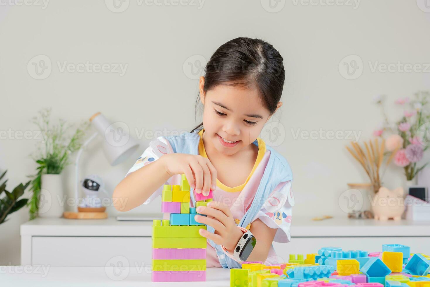 little girl is happy Playing colorful block puzzles. in the white room photo
