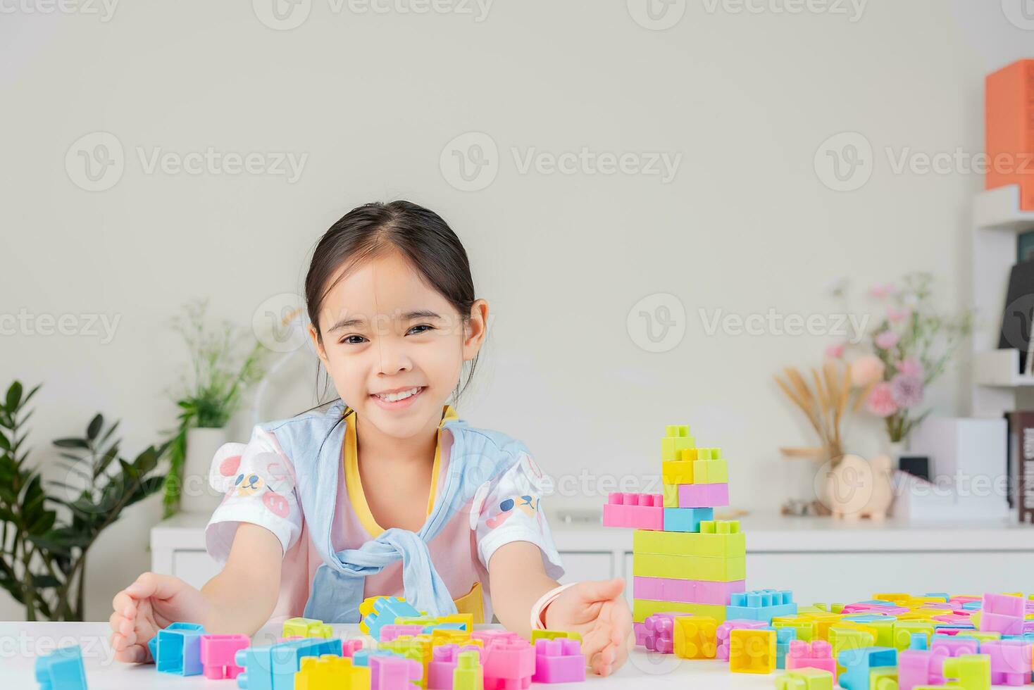 little girl is happy Playing colorful block puzzles. in the white room photo