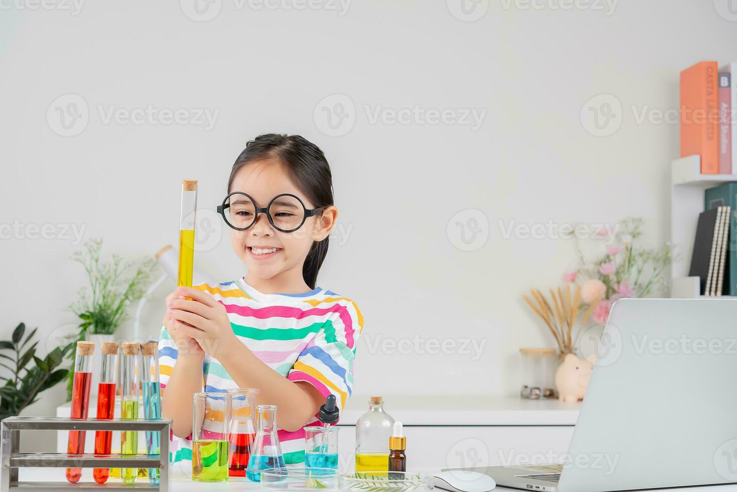 Asian little girl working with test tube science experiment in white classroom photo