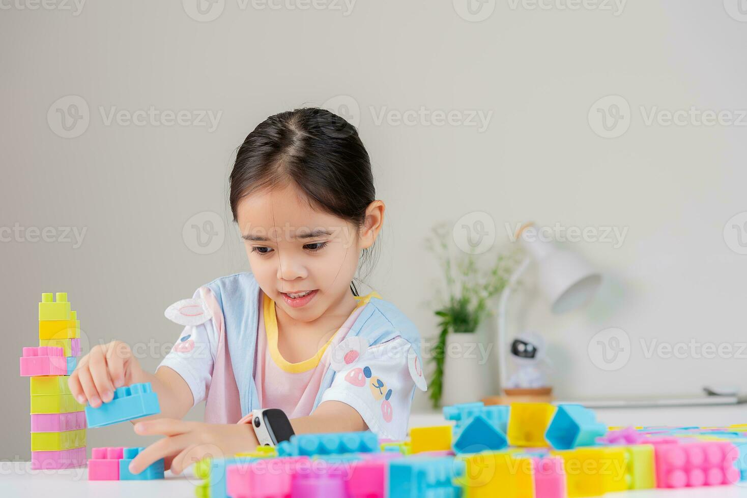 little girl is happy Playing colorful block puzzles. in the white room photo