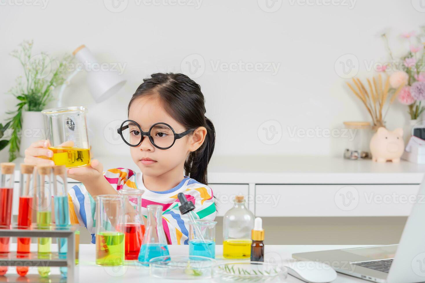 Asian little girl working with test tube science experiment in white classroom photo