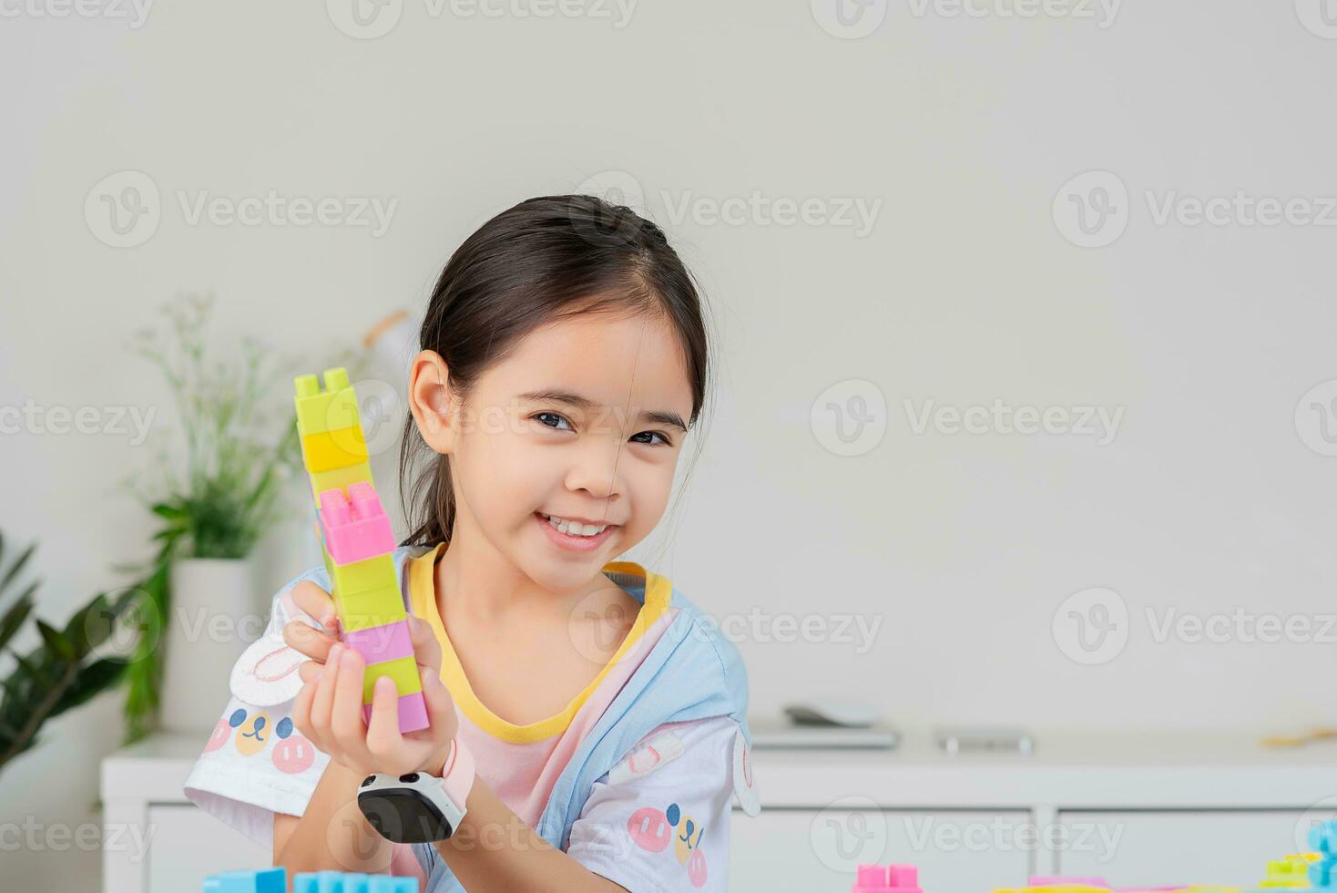 little girl is happy Playing colorful block puzzles. in the white room photo